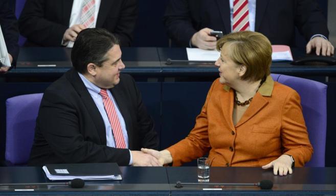 La canciller Angela Merkel estrecha la mano al ministro de Economa y...