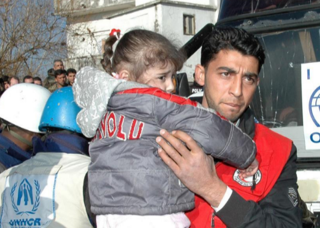 Un trabajador de la Cruz Roja siria ayuda a una nia evacuada de...