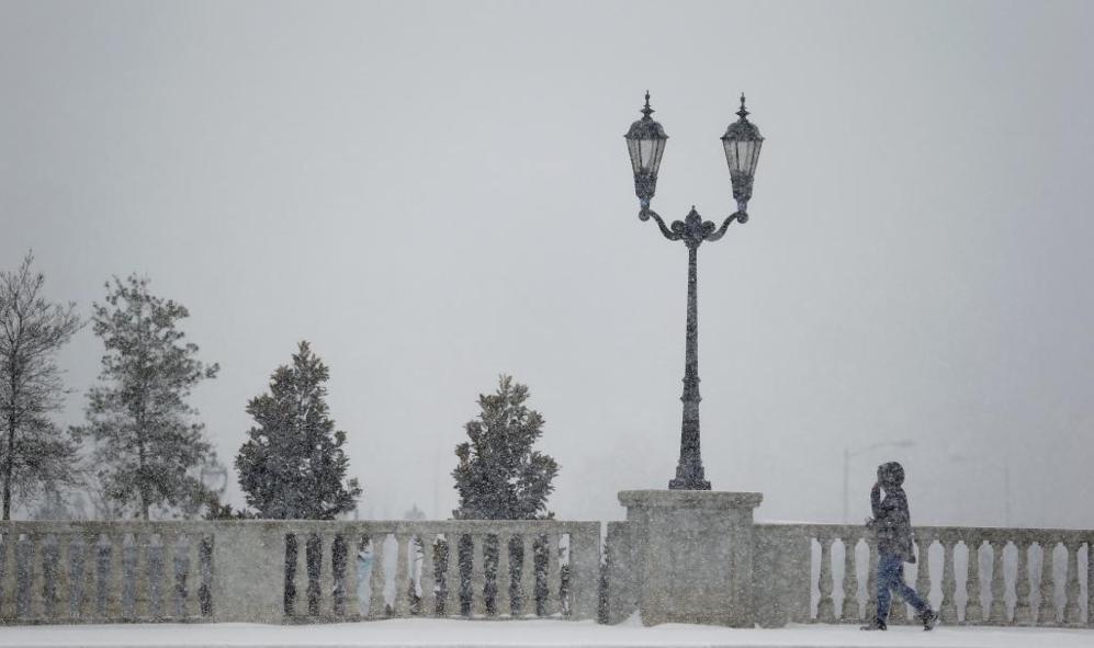 Un peatn pasea bajo una intensa nevada en Charlotte (Carolina del...