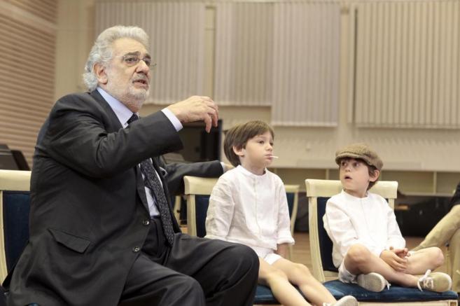 Plácido Domingo, con unos niños, durante una rueda de prensa en el...