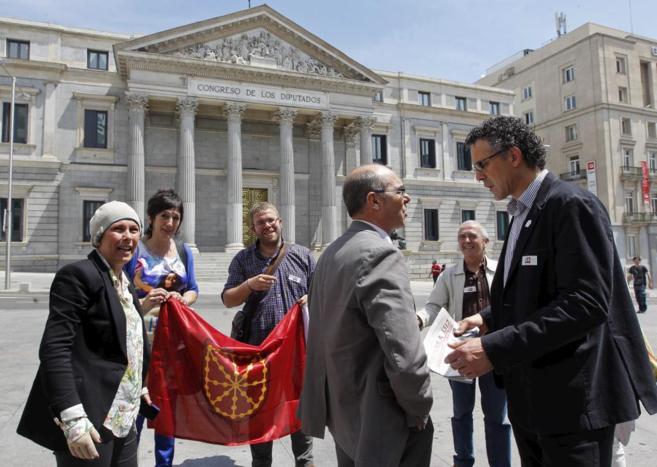 Uxue Barkos (i) con una bandera navarra frente al Congreso; Francisco...