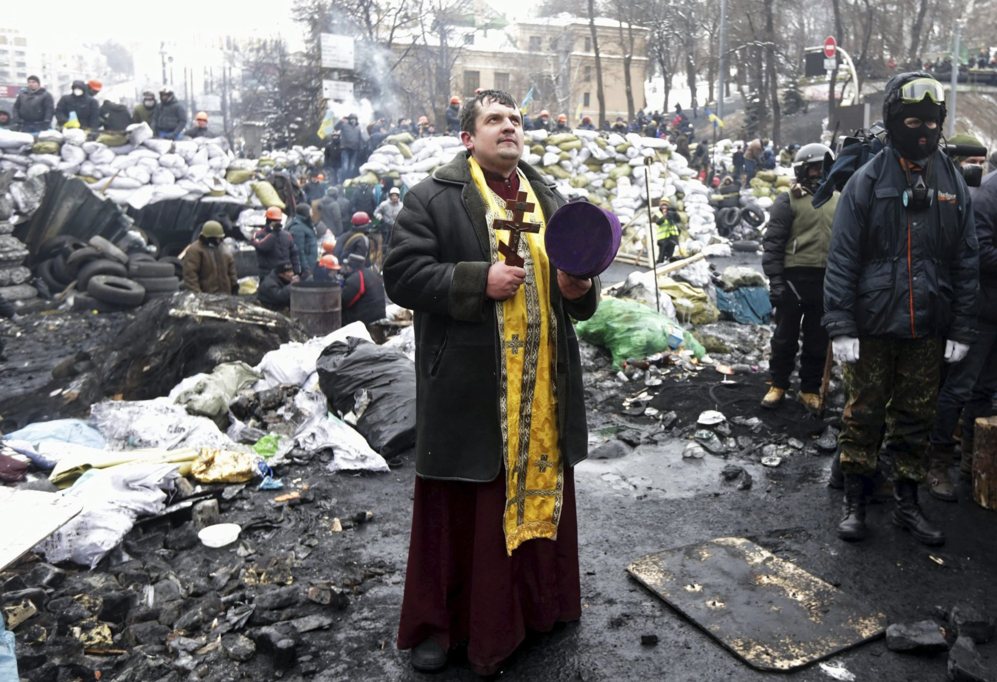 28 de Enero del 2014. Un sacerdote ucraniano reza ante una barricada.