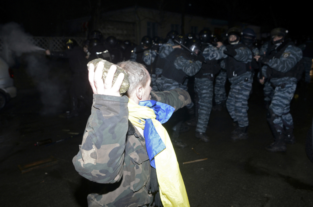 10 de Enero del 2014. Un activista tira una piedra contra la polica...