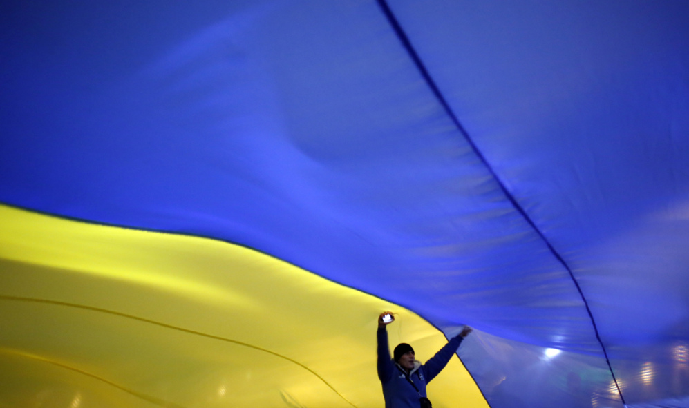 19 de Diciembre de 2013. Una mujer baila debajo de una enorme bandera...