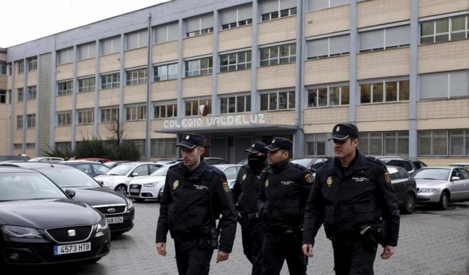 Cuatro policías, ante el Colegio Valdeluz de Madrid.