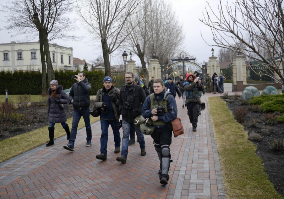 Periodistas y opositores caminan por el terreno de Mezhyhirya,...