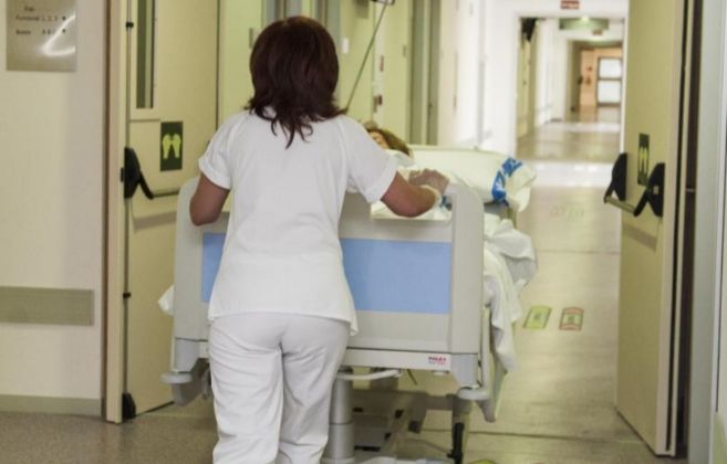 Una enfermera empuja la camilla de un paciente