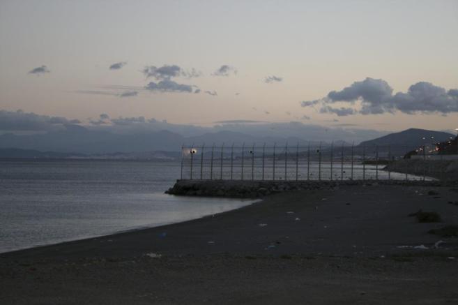 La escollera y la valla de la frontera entre Ceuta y Marruecos donde...