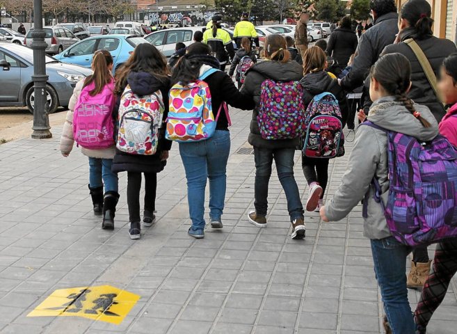 Varias nias caminan hacia su colegio en el barrio de Torrefiel.