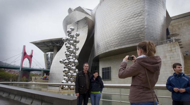 Dos turistas se fotografan frente al Museo Guggenheim, sede del...