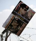 Un poster de Al Sisi frente a un polica.