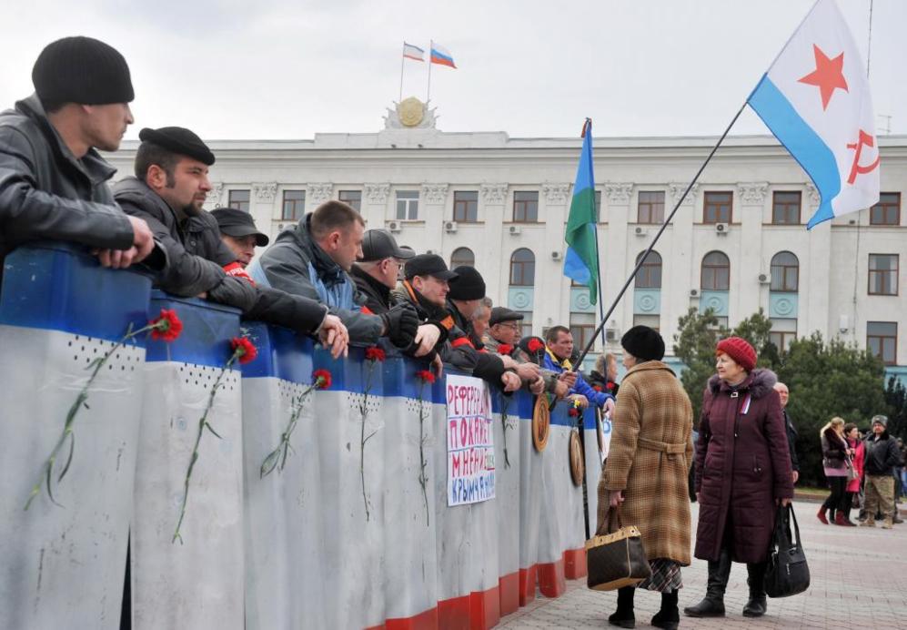 Un grupo de hombres partidarios de Rusia montan guardia con escudos y...