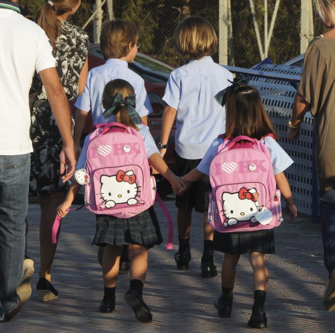 Una familia lleva a sus hijos al colegio el primer da de colegio.