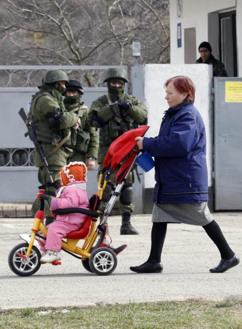 Una mujer y unos militares rusos en una base ucraniana cerca de...