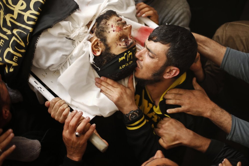 Un palestino besa el cuerpo de Mousab Al-zaani durante su funeral en...