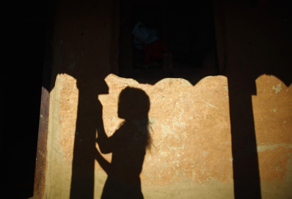 La sombra de una joven en la pared de su casa en la colina de la aldea...