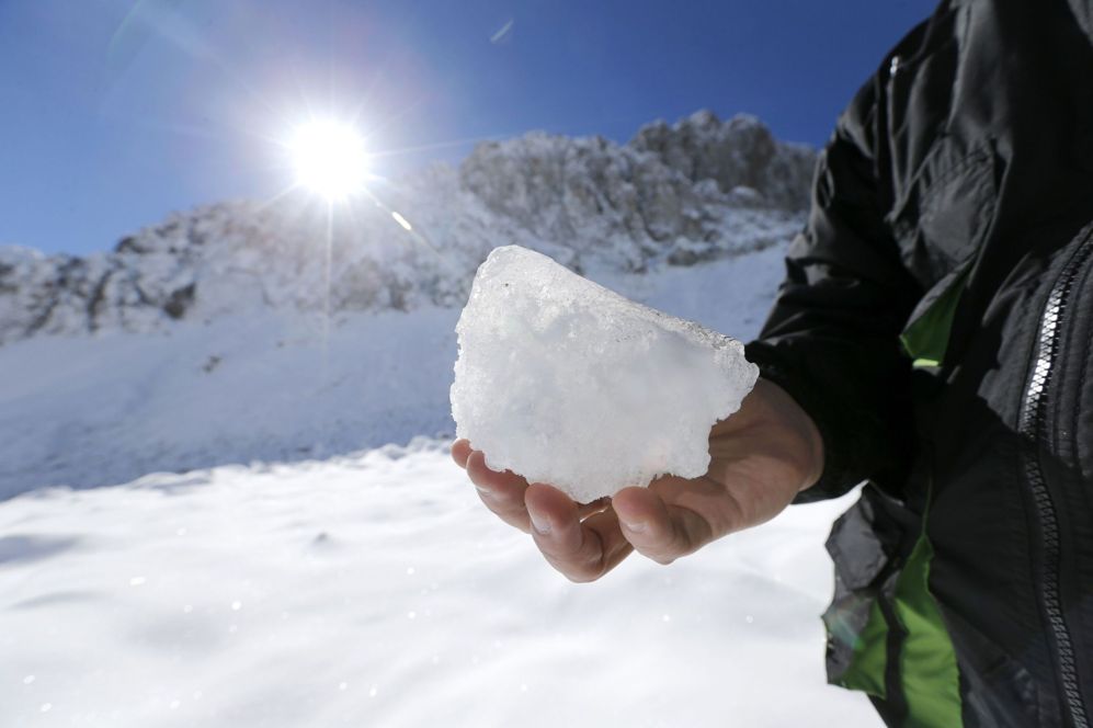 Un activista de Greenpeace sostiene un trozo de hielo en el glaciar...