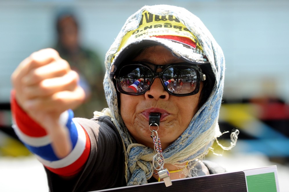 Un manifestante contra el gobierno hace gestos durante una...