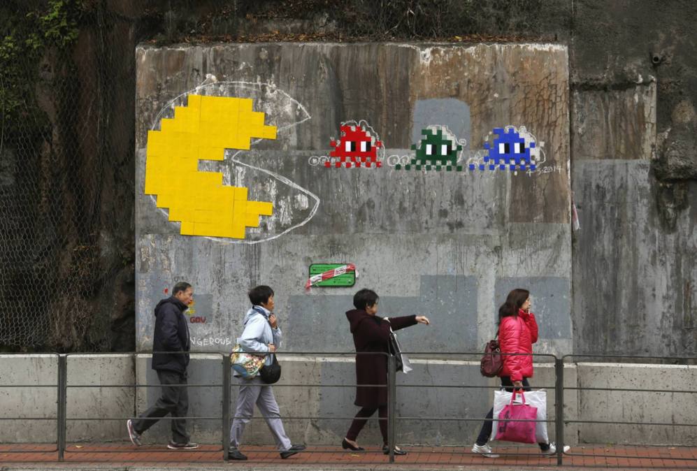 La gente pasa por delante de una copia de una obra de arte Pac-Man...