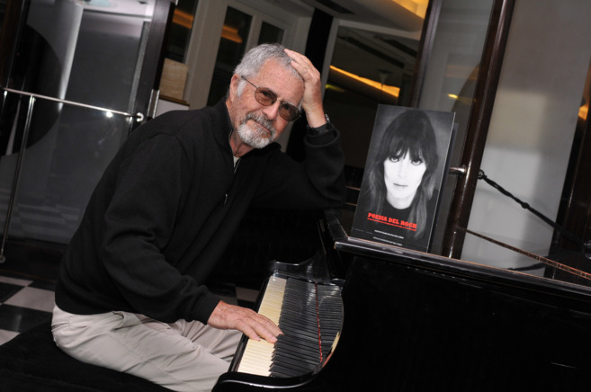 El fotgrafo Guy Webster posa en el piano del hotel malagueo que...
