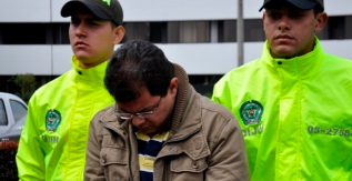 El detenido, con dos agentes colombianos.