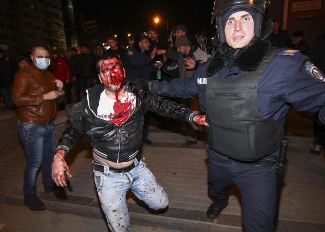Un polica arrastra a uno de los manifestantes, herido en la cara, en...