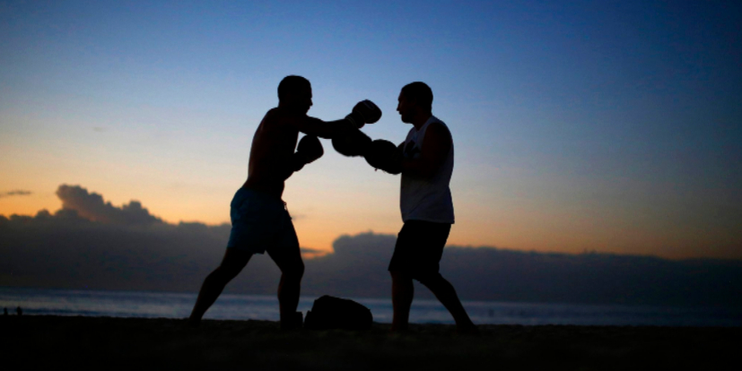 Un boxeador entrena antes de la salida del sol en la playa de Bondi de...