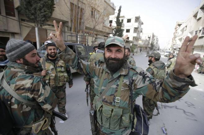 Un soldado afn a Damasco hace este domingo el signo de la victoria...
