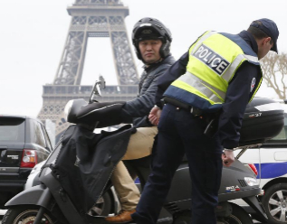 Un polica comprueba la matrcula de una moto en Pars.
