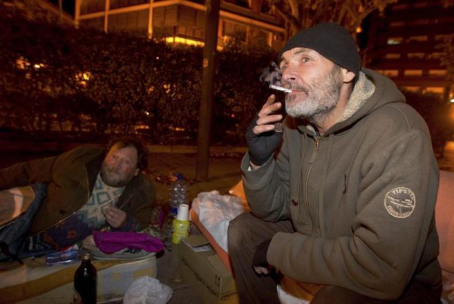 Indigentes en una calle de Valencia se disponen a pasar la noche