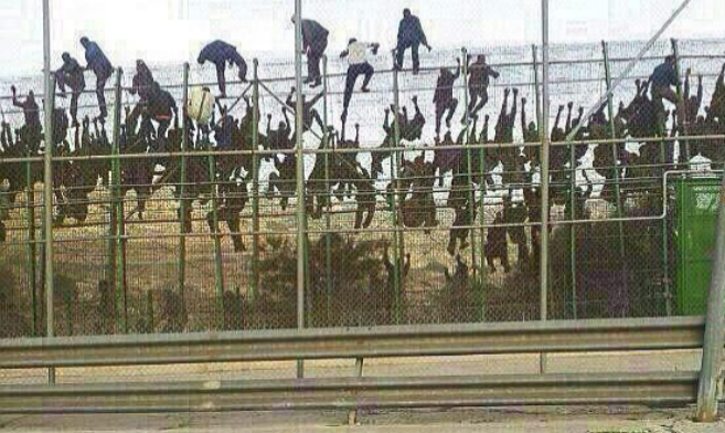 Momento del salto masivo a la valla de Melilla.