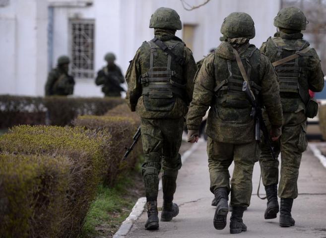 Soldados rusos patrullan ante una base naval ucraniana en Sebastopol.