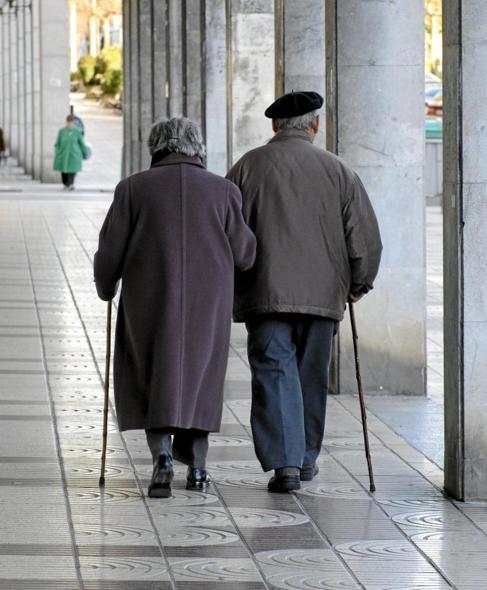 Una pareja de ancianos pasea por Bilbao