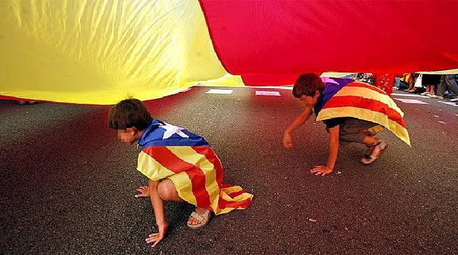 Dos nios con la bandera independentista catalana a modo de capa, en...