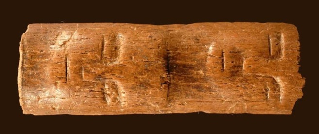 Rostros tallados sobre el hueso de una costilla de toro primitivo.