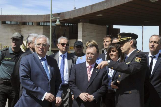 Un hombre en uniforme negro y los presidentes de Ceuta y Melilla en...