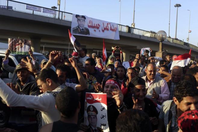 Partidarios de Abdelfatah al Sisi agitan banderas egipcias en la plaza...