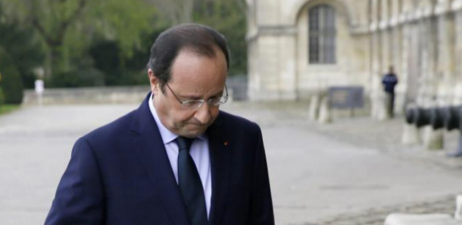 El presidente Hollande, cabizbajo, dirigiéndose a recibir al...