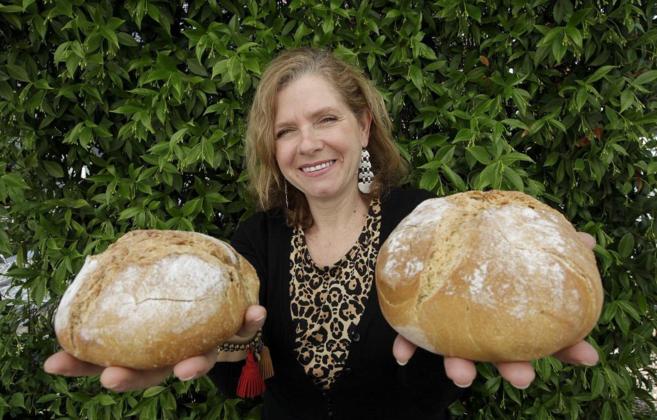Pilar Barceló, directora general de Agrasys, posa con dos panes...