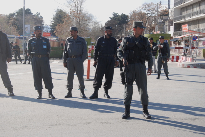 Policías afganos hacen guardia tras el atentado en la calle donde...