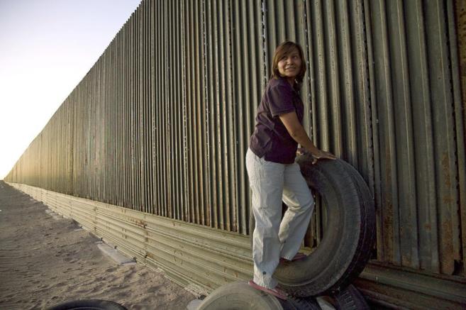 Una mujer junto a la valla fronteriza entre Mxico y EEUU en San Luis...
