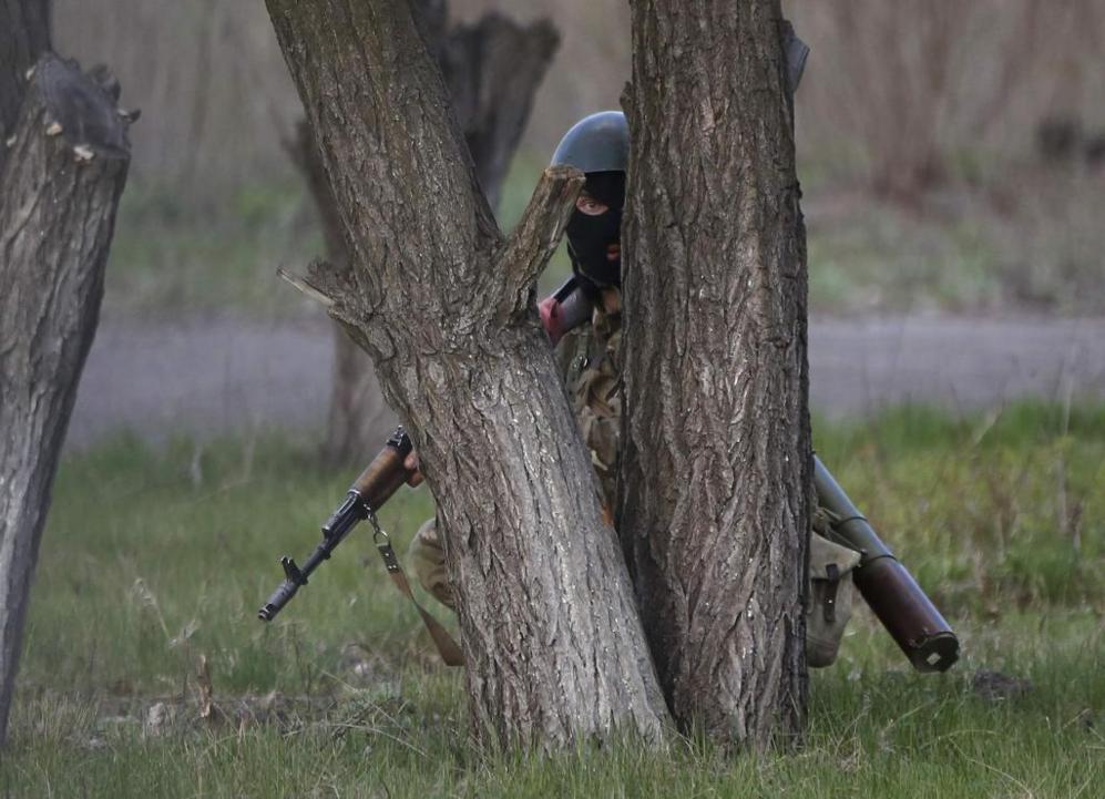 Un soldado ucraniano se cubre tras un rbol durante la operacin...