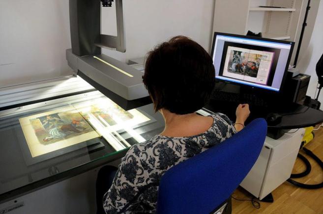 Una empleada de la biblioteca digital escanea un documento.