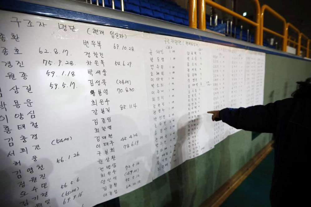 Un hombre repasa la lista de los nombres de los pasajeros rescatados...