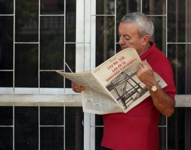 Un hombre lee un tabloide especial del diario 'Granma',...