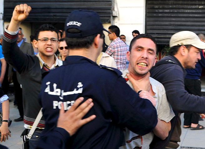 Un agente de la polica argelina arresta a un integrante del...