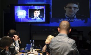 Periodistas escuchan la pregunta de Snowden.