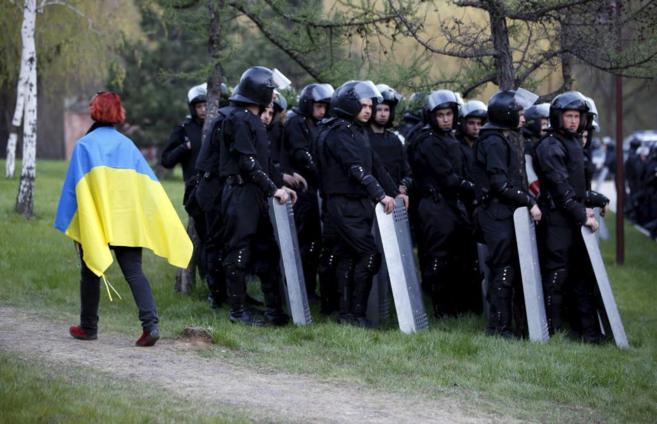 Una manifestante proucraniana pasa por delante de un grupo de...
