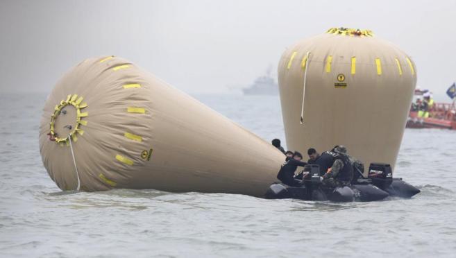 Los equipos de rescaten instalan flotadores en la zona del mar de...