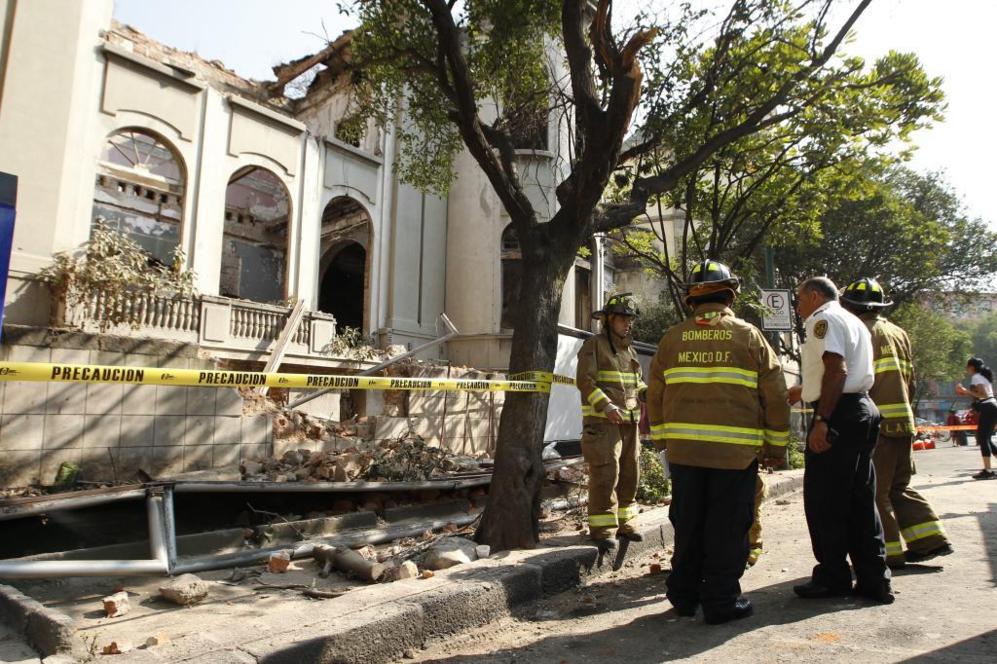 Bomberos inspeccionan el derrumbe de parte de una casa antigua en la...